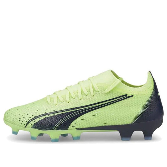 A pair of Puma Ultra Match FG/AG women's soccer cleats in green and black color.